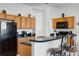 Functional kitchen features wooden cabinets, a breakfast bar, and modern appliances for all your cooking needs at 509 Cadiz Loop, Davenport, FL 33837