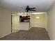 Open-concept living area with neutral carpet, ceiling fan, and adjoining kitchen at 5160 Conroy Rd # 1414, Orlando, FL 32811
