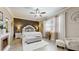 Beautiful main bedroom featuring a tray ceiling, a decorative headboard, and a cozy sitting area at 5457 Animosh Ct, Polk City, FL 33868