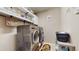 Modern laundry room with stainless steel washer and dryer and ample shelving at 5457 Animosh Ct, Polk City, FL 33868