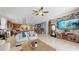 Open-concept living space with a stone-accented wall, large TV, and a smooth transition to the kitchen and dining area at 5457 Animosh Ct, Polk City, FL 33868