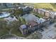 Aerial view of apartments featuring a community pool, pond, and parking areas at 5530 Chrishire Way # D204, Orlando, FL 32822