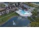 Aerial view shows a large community pool and lovely pond area with apartments at 5530 Chrishire Way # D204, Orlando, FL 32822