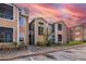 Two-story condo with tan siding, well-maintained landscaping against a vibrant sky at 5530 Chrishire Way # D204, Orlando, FL 32822