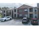 Exterior of the brick apartment building with parking area and well-maintained landscaping at 5530 Chrishire Way # D204, Orlando, FL 32822