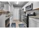 Modern kitchen featuring white cabinets, granite countertops, and stainless steel appliances at 5530 Chrishire Way # D204, Orlando, FL 32822