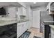 Updated kitchen with white cabinets, granite countertops, and stainless steel appliances at 5530 Chrishire Way # D204, Orlando, FL 32822