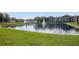 Scenic pond with fountains surrounded by manicured green grass and multi-story residential buildings at 5530 Chrishire Way # D204, Orlando, FL 32822