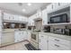 Well-lit kitchen featuring white cabinets, countertops, and tile backsplash at 6 Escondido Cir # 58, Altamonte Springs, FL 32701