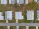 An overhead shot showing multiple homes with paved driveways in the community and tree coverage at 6475 Peppertree Ne Path, Winter Haven, FL 33881
