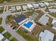Aerial view of a community pool, clubhouse, and shuffleboard courts at 6475 Peppertree Ne Path, Winter Haven, FL 33881