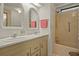 Bathroom featuring a double vanity with arched mirrors, a shower-tub combination, and a well-lit space at 6475 Peppertree Ne Path, Winter Haven, FL 33881