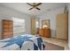 Bedroom featuring matching dressers, a window with blinds, and a ceiling fan for a bright and airy feel at 6475 Peppertree Ne Path, Winter Haven, FL 33881