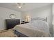 A modest bedroom with a ceiling fan, a bed with an ornate headboard, and a dresser at 6475 Peppertree Ne Path, Winter Haven, FL 33881
