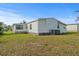 Rear view of home showing the siding, windows, and well-kept lawn at 6475 Peppertree Ne Path, Winter Haven, FL 33881