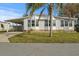 Front view of home with palm tree and carport; set in a well-kept lawn at 6475 Peppertree Ne Path, Winter Haven, FL 33881