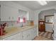 Bright kitchen featuring white cabinets, a double basin sink, and a view of a classic-style kitchen nook at 6475 Peppertree Ne Path, Winter Haven, FL 33881