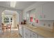Cozy kitchen featuring white cabinetry, a double basin sink, and an adjacent dining nook with natural light at 6475 Peppertree Ne Path, Winter Haven, FL 33881