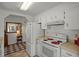 Well-lit kitchen with white appliances, including a refrigerator and oven, with a view to a dining area at 6475 Peppertree Ne Path, Winter Haven, FL 33881