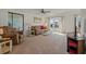 Bright living room with neutral carpet, plush seating, and large windows, creating an inviting space at 6475 Peppertree Ne Path, Winter Haven, FL 33881