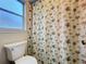 This bathroom features a decorative shower curtain and a bright window view at 734 Olympic Cir # 30, Ocoee, FL 34761