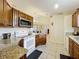 Well-lit kitchen features wood cabinetry, granite countertops, and stainless steel appliances at 734 Olympic Cir # 30, Ocoee, FL 34761