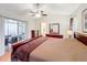 Main bedroom with sliding glass doors to lanai, ensuite bath, and ceiling fan at 734 Olympic Cir # 30, Ocoee, FL 34761