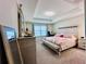 Spacious bedroom featuring a tray ceiling, large window, and neutral carpet at 8628 Dufferin Ln, Orlando, FL 32832