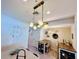 Open dining area with a hanging light fixture and adjacent kitchen island and pantry at 8628 Dufferin Ln, Orlando, FL 32832