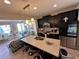 Modern kitchen with dark cabinets, quartz countertops, stainless steel appliances, and an island with seating at 8628 Dufferin Ln, Orlando, FL 32832