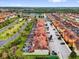 An aerial view of colorful townhomes with tile roofs, palm trees, and parking at 8971 Majesty Palm Rd, Kissimmee, FL 34747