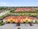 An aerial view shows colorful townhomes, palm trees, and extensive parking areas at 8971 Majesty Palm Rd, Kissimmee, FL 34747