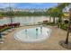 Community splash pad featuring interactive water elements, surrounded by lounge chairs and landscaping, with a tranquil lake view at 8971 Majesty Palm Rd, Kissimmee, FL 34747