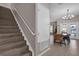 View of the staircase and dining room featuring a modern chandelier at 8971 Majesty Palm Rd, Kissimmee, FL 34747