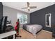 Bedroom with a ceiling fan and a grey accent wall at 9012 Tuscan Cypress St, Kissimmee, FL 34747