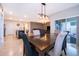Open dining area featuring a modern chandelier, dining table set for six, and patio access, with a view into the living area at 9012 Tuscan Cypress St, Kissimmee, FL 34747