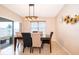 Elegant dining room with modern lighting fixture, table set for six, and glass sliding doors that lead to the patio at 9012 Tuscan Cypress St, Kissimmee, FL 34747