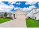 Inviting home features a two car garage, beautiful lawn, and lovely curb appeal under a bright, cloudy sky at 9012 Tuscan Cypress St, Kissimmee, FL 34747
