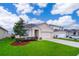 Attractive single-Gathering home with green lawn, two-car garage and professional landscaping under a sunny, blue sky at 9012 Tuscan Cypress St, Kissimmee, FL 34747
