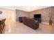 Comfortable living room featuring stylish accent wall, neutral tile flooring, and modern furniture illuminated by pendant lighting at 9012 Tuscan Cypress St, Kissimmee, FL 34747