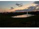Evening view of a scenic pond with a fountain and colorful sunset backdrop at 9012 Tuscan Cypress St, Kissimmee, FL 34747