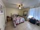 A bedroom with a ceiling fan, tile flooring, and a dresser with a vanity mirror at 996 Dolphin Dr, Winter Garden, FL 34787