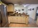 A kitchen with a stainless steel refrigerator and view of the adjacent dining area with ceiling fans at 996 Dolphin Dr, Winter Garden, FL 34787