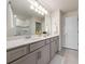 Well-lit bathroom with double sinks, granite countertop, and tiled floors at 10414 Folly Beach Rd, Orlando, FL 32827