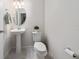 Clean powder room with pedestal sink, oval mirror, and neutral decor at 10414 Folly Beach Rd, Orlando, FL 32827