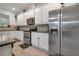 Open kitchen with stainless steel appliances, white cabinetry and dark countertops at 11454 Wakeworth St, Orlando, FL 32836