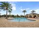 Community pool surrounded by palm trees and comfortable lounge chairs at 11454 Wakeworth St, Orlando, FL 32836