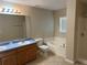Well-lit bathroom features a double sink vanity, bathtub, and a separate shower at 138 Inconnu Ct, Kissimmee, FL 34759