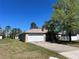 Exterior view featuring an attached garage, mature trees, and a well-maintained front lawn at 138 Inconnu Ct, Kissimmee, FL 34759