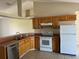 Functional kitchen with wood cabinets, tile flooring, and white appliances at 138 Inconnu Ct, Kissimmee, FL 34759